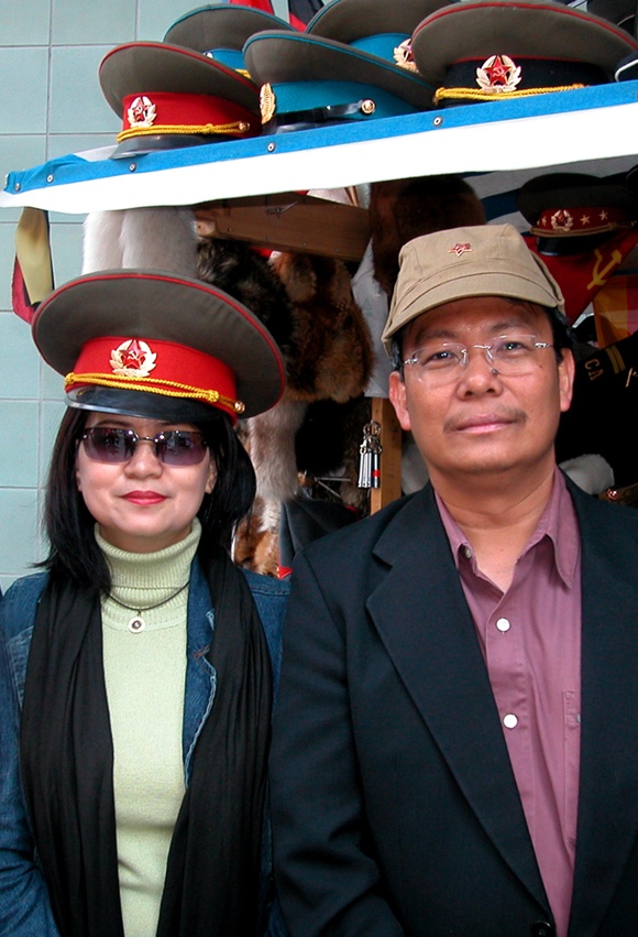Trying on Russian military hats on a sidewalk souvenir stall